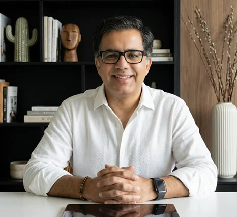 Vibhav Taneja, Founder of Smart Sense, smiling at a desk with hands folded, featured in a client testimonial for Prox Digital Agency. He wears a white shirt and glasses against a modern office bookshelf background.